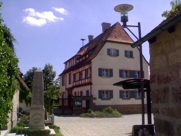 Das Bild zeigt das alte Schulhaus und heutige Gemeindehaus in Seukendorf.