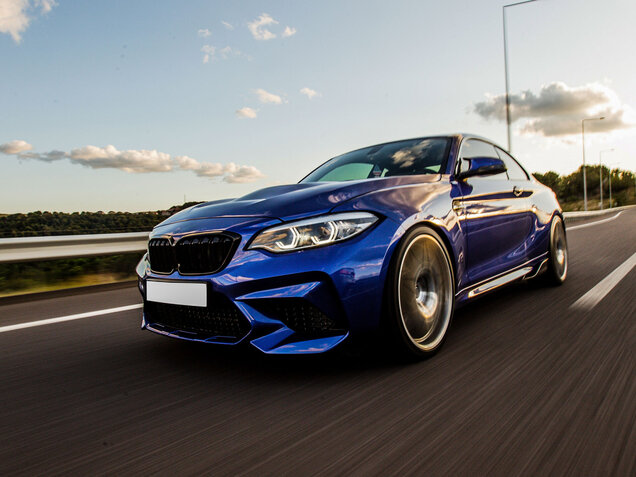 Blaues, sportliches Auto auf einer Straße fahrend.