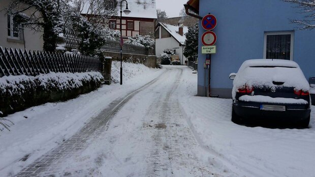 Bild einer verschneiten Straße einer Siedlung.