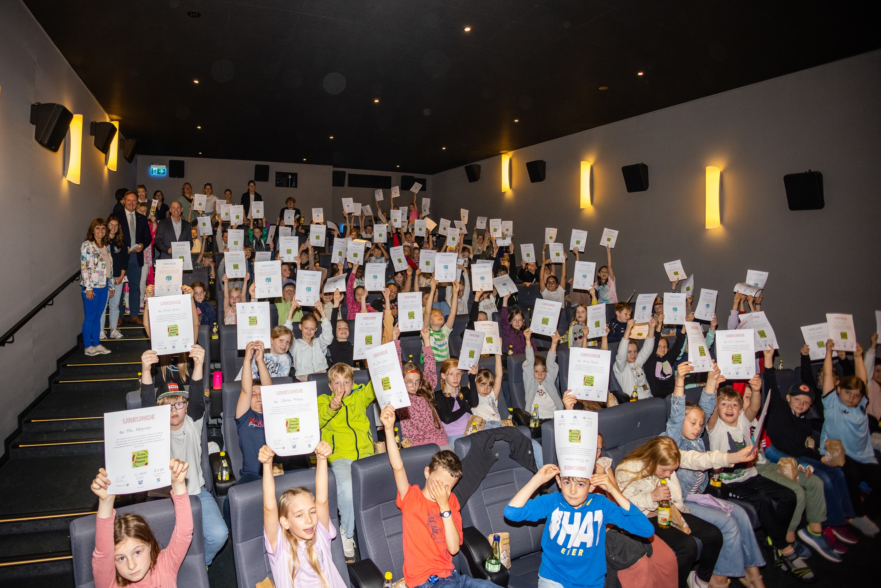 Die glücklichen Kinder halten die Urkunden hoch.