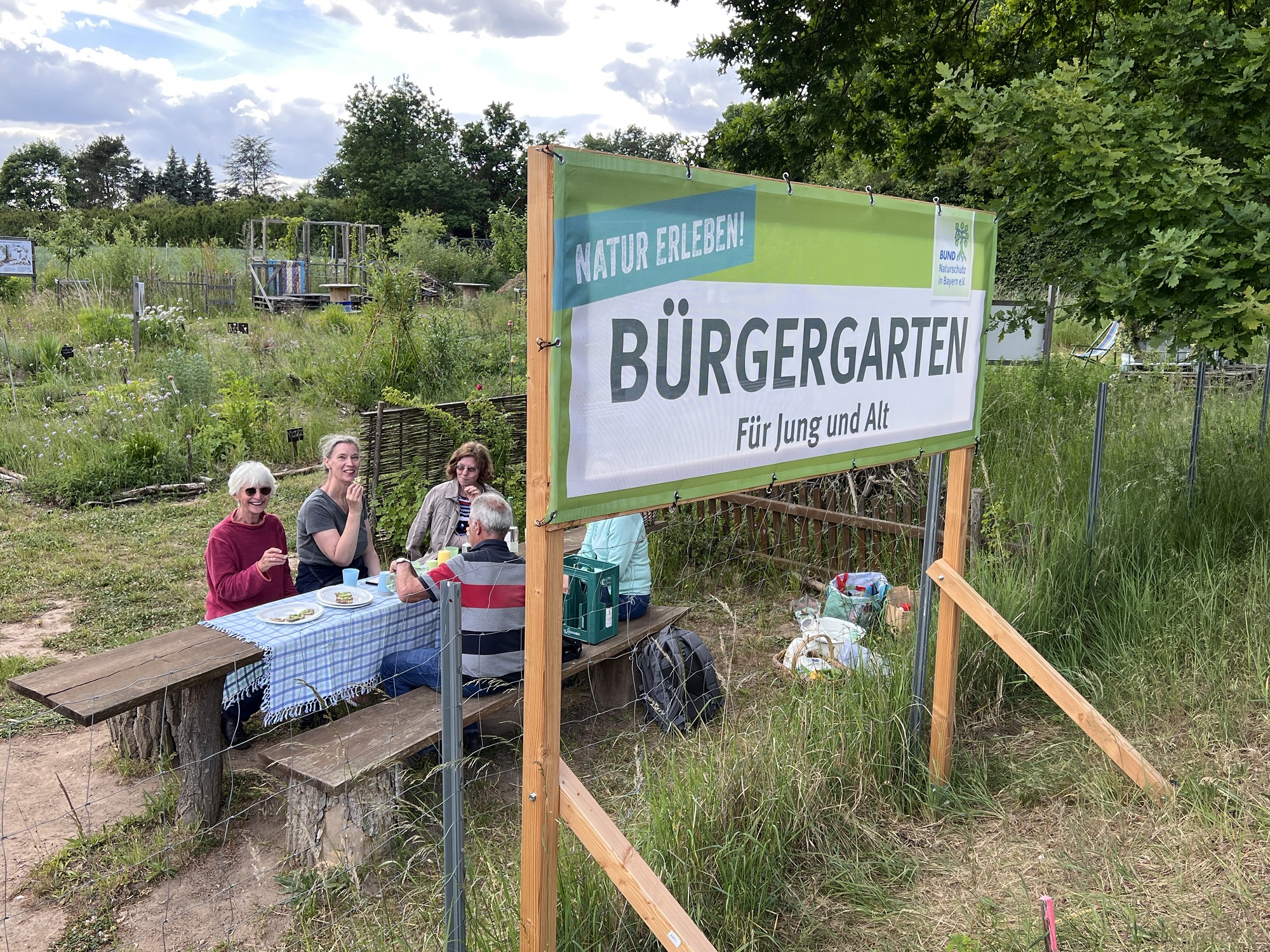 Das Bild zeigt ein Schild mit der Aufschrift: Bürgergarten für Jung und Alt. 