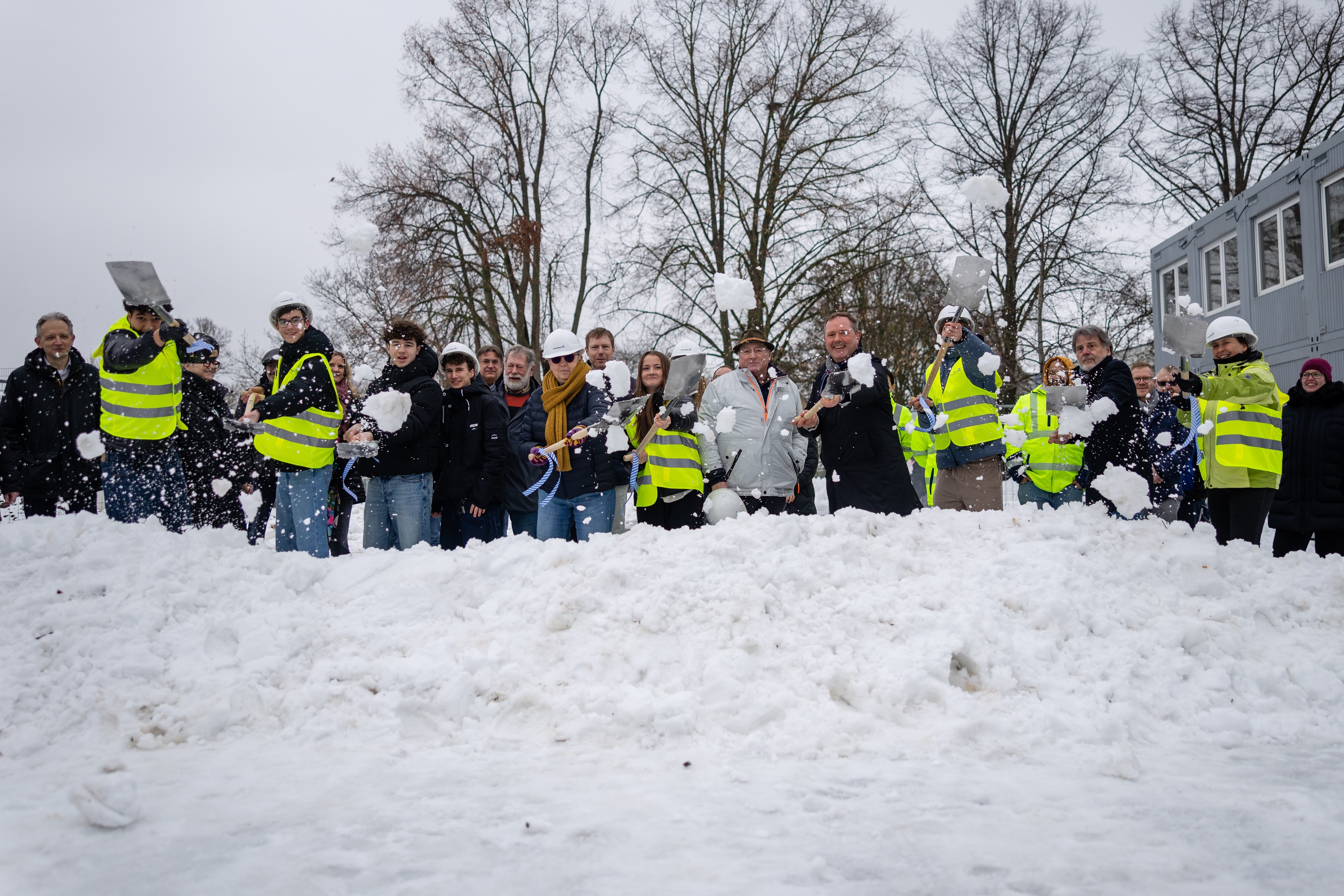 Landrat Bernd Obst, die Schulleitung und Schülerinnen und Schüler des Gymnasiums Oberasbach sowie die Bauverwaltung des Landratsamtes Fürth führten den symbolischen ersten Spatenstich aus — wegen der winterlichen Witterung musste allerdings ein stattlicher Schneehaufen herhalten. Ein Spatenstich, der anders, aber umso treffender in dieser Woche war.